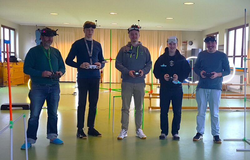 Im Bild wird eine Gruppe Fernpiloten mit Funkfernsteuerung und Videobrille gezeigt.